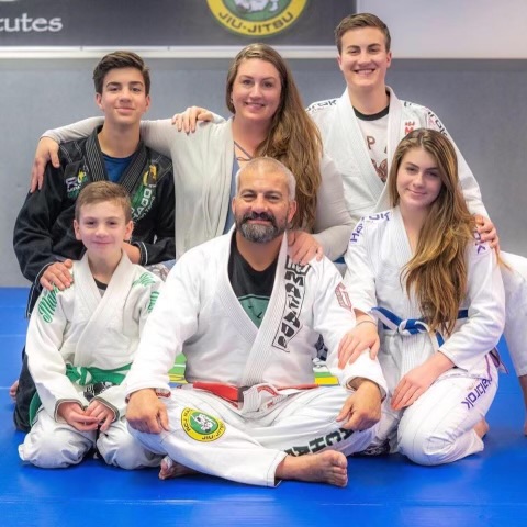 Carlos Machado with his family on the mat in their jiu-jitsu gis